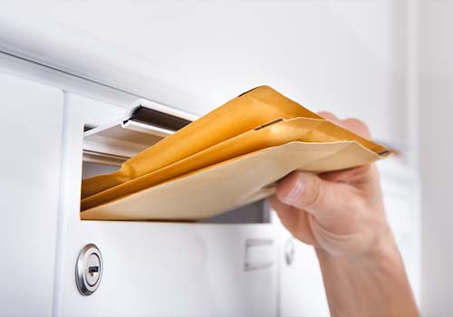 Man putting media mail in mailbox