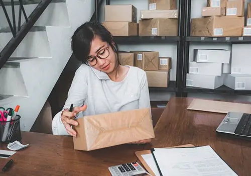 A woman getting packages ready for delivery.